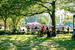 Besuchergruppe auf Decken und Klappstühlen beim Picknick im Stadtgrün Besuchergruppe auf Decken und Klappstühlen beim Picknick im Stadtgrün