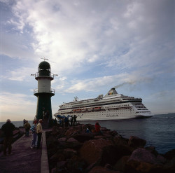 Blick von der Westmole auf ein ausfahrendes Kreuzfahrtschiff