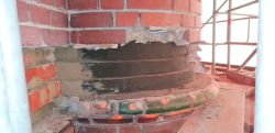 Die Außenwände des Rostocker Wasserturms sind teilweise schon saniert, weisen aber auch noch Lücken auf. Holzverstrebungen stützen freiliegendes Mauerwerk.