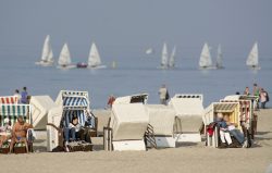 Strandkörbe und Segler am Strand von Warnemünde