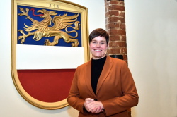 Eva-Maria Kröger vor dem Stadtwappen im oberen Foyer des Rathauses.