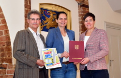 Staatssekretärin Ines Jesse (Bildmitte) übergibt den Zuwendungsbescheid an Oberbürgermeisterin Eva-Maria Kröger (r.), in Anwesenheit des Leiters des Rostocker Tiefbauamtes Heiko Tiburtius 